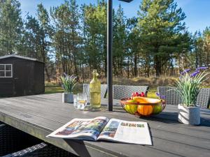 a table with a book and a bowl of fruit at Holiday Home Dorris - 4-3km from the sea by Interhome in Nørre Nebel