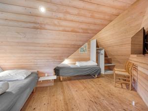 two beds in a room with wooden walls at Holiday Home Dorris - 4-3km from the sea by Interhome in Nørre Nebel