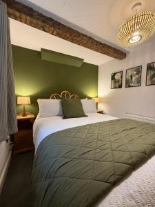 a bedroom with a large bed with a green wall at The Whitchurch Apartment- The Painted Rooms in Whitchurch