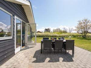 a patio with a table and chairs on it at Holiday Home Ingward - 300m to the fjord by Interhome in Tarm