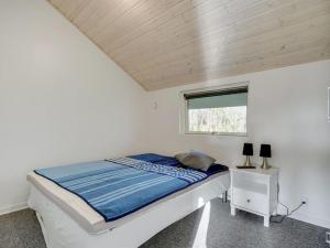 a small bedroom with a bed and a window at Holiday Home Ingward - 300m to the fjord by Interhome in Tarm