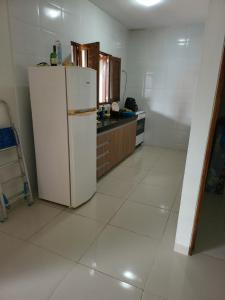 a kitchen with a white refrigerator in a room at Chacaras Leos in Arapiraca