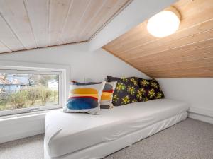 Zimmer mit einem Bett mit Kissen und einem Fenster in der Unterkunft Holiday Home Marten - 1-2km to the inlet by Interhome in Hemmet