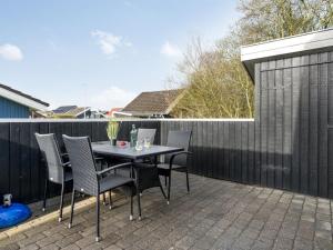 eine Terrasse mit einem Tisch und Stühlen auf einem Zaun in der Unterkunft Holiday Home Marten - 1-2km to the inlet by Interhome in Hemmet