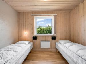 two beds in a room with a window at Holiday Home Saara - 700m to the inlet by Interhome in Tarm