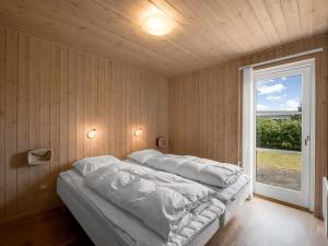 a bed with white sheets in a room with a window at Holiday Home Saara - 700m to the inlet by Interhome in Tarm +22 photos