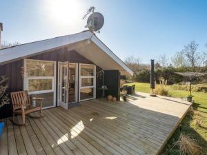 a house with a deck and a satellite at Holiday Home Gunde - 300m to the fjord by Interhome in Hemmet