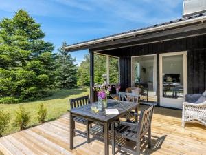 une terrasse en bois avec une table et des chaises. dans l'établissement Holiday Home Cristal - 400m to the fjord by Interhome, à Hemmet
