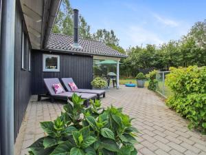 eine Terrasse mit zwei Stühlen und einem Tisch in der Unterkunft Holiday Home Ulrikke - 12km from the sea by Interhome in Oksbøl