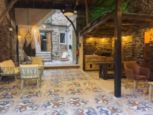 a patio with a table and chairs and a stone wall at Go Compostela Apartamento 4 pax in Sarria +20 photos