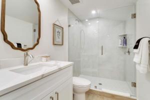 a white bathroom with a sink and a shower at New Downtown Cottage on Camden #1 in Stuart