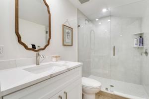 a bathroom with a sink and a toilet and a mirror at New Downtown Cottage on Camden #1 in Stuart