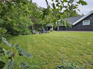 a yard with benches in front of a house at Holiday Home Matthis - 500m to the inlet by Interhome in Skjern