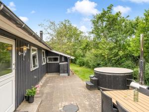 Un patio con jacuzzi al lado de una casa. en Holiday Home Embla - 500m to the fjord by Interhome, en Ulfborg