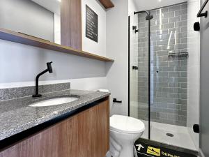 a bathroom with a toilet and a sink and a shower at 2 quartos - AC - Home office - WiFi in Água Boa +5 photos