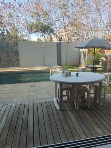 a table and umbrella on a deck next to a pool at Mira lune villa in Flic-en-Flac