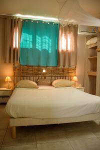 1 dormitorio con 1 cama grande y cortina azul en Eden Sea Villa, en Pointe-Noire