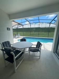 a patio with a table and chairs and a swimming pool at Magical Home with private pool and close to parks in Kissimmee +7 photos