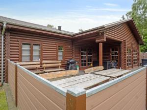 una baita di tronchi con una recinzione in legno di fronte ad essa di Holiday Home Frederica - 30km from the sea by Interhome a Toftlund