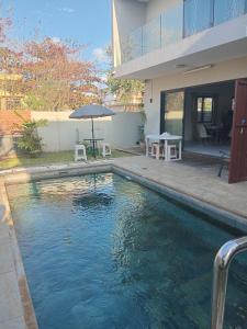 a swimming pool in front of a house at Mira lune villa in Flic-en-Flac