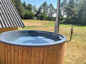 a large hot tub in a yard with a fence at Holiday Home Ødke - 3-5km from the sea by Interhome in Nørre Nebel