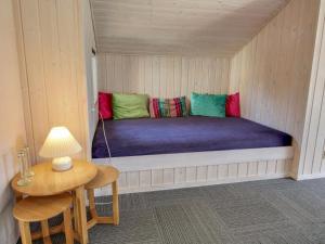 Posto letto in una piccola camera con tavolo e lampada di Holiday Home Kody - 350m to the fjord by Interhome a Ulfborg Altre 13 foto