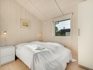 a white bed in a room with a window at Holiday Home Duschanka - 50m to the inlet by Interhome in Fredericia