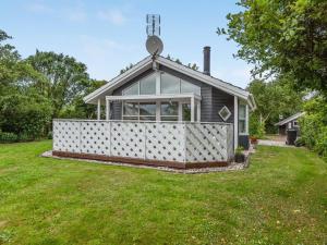 ein kleines Haus mit einem weißen Zaun im Hof in der Unterkunft Holiday Home Yara - 1km to the inlet by Interhome in Hemmet