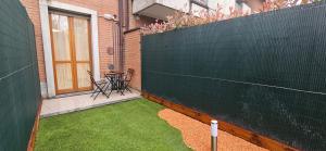 a backyard with a green fence and a table and chairs at Dream House in Garbagnate Milanese