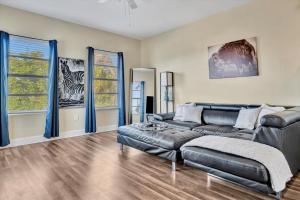 ein Wohnzimmer mit Ledersofa und zwei Fenstern in der Unterkunft Amazing Location Downtown Tampa WorkSpace in Tampa