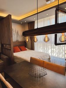 a bedroom with a bed and a table and lights at Evergreen Lux in Kopaonik