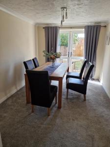 a dining room with a table and chairs and a window at SK Short Let 