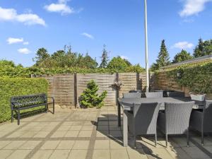 a patio with a table and chairs and a fence at Holiday Home Emmik - 150m from the sea by Interhome in Børkop
