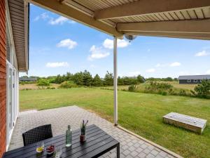 a patio with a table and chairs and a field at Holiday Home Clement - 500m to the fjord by Interhome in Skjern