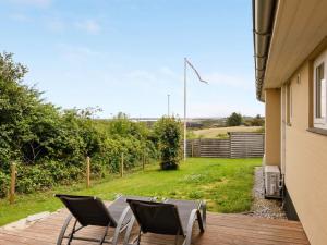 a patio with two chairs and a table on a deck at Holiday Home Dagne - 400m to the fjord by Interhome in Struer