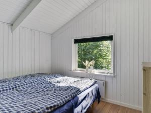 a white bedroom with a bed and a window at Holiday Home Yngve - 56-5km from the sea by Interhome in Give