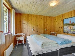 a bedroom with a bed in a wooden wall at Holiday Home Ulrike - 600m to the fjord by Interhome in Ulfborg
