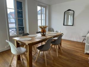 a dining room with a wooden table and chairs at Beau Repère Coulommiers 77 in Coulommiers +13 photos