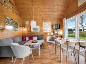 a living room with a couch and tables and chairs at Holiday Home Terese - 45km from the sea by Interhome in Grindsted