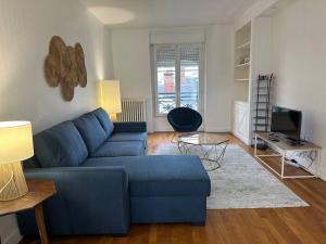 a living room with a blue couch and a tv at Beau Repère Coulommiers 77 in Coulommiers