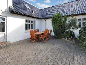 a patio with a table and chairs in front of a house at Holiday Home Sophia - 8km from the sea by Interhome in Thisted