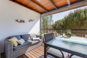 eine Terrasse mit einem Sofa und einem Tisch auf einer Terrasse in der Unterkunft Elegant Apartment in Lagos with Pool in Lagos