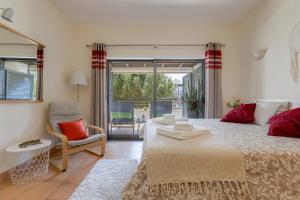 ein Schlafzimmer mit einem Bett und einem Stuhl und einem Fenster in der Unterkunft Elegant Apartment in Lagos with Pool in Lagos + 42 Fotos