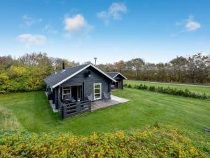 a small black house on a grass field at Holiday Home Engeline - 300m to the inlet by Interhome in Vemb
