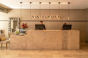 a lobby with two people sitting at a counter with laptops at Vincci Baixa in Lisbon +39 photos