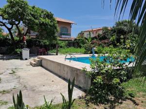 a swimming pool in a yard next to a house at Casas Aluguel Temporada Pousada Village Maçarico in Salinópolis