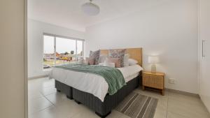 a bedroom with a large bed and a window at Namib Nook in Swakopmund