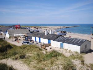 a building on a beach next to the ocean at Holiday Home Biriel - 1km from the sea by Interhome in Thisted