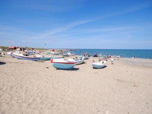 a group of boats sitting on a sandy beach at Holiday Home Biriel - 1km from the sea by Interhome in Thisted