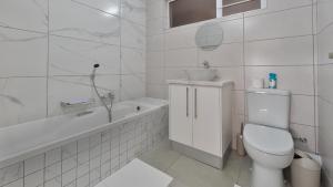 a white bathroom with a toilet and a sink at Namib Nook in Swakopmund +14 photos